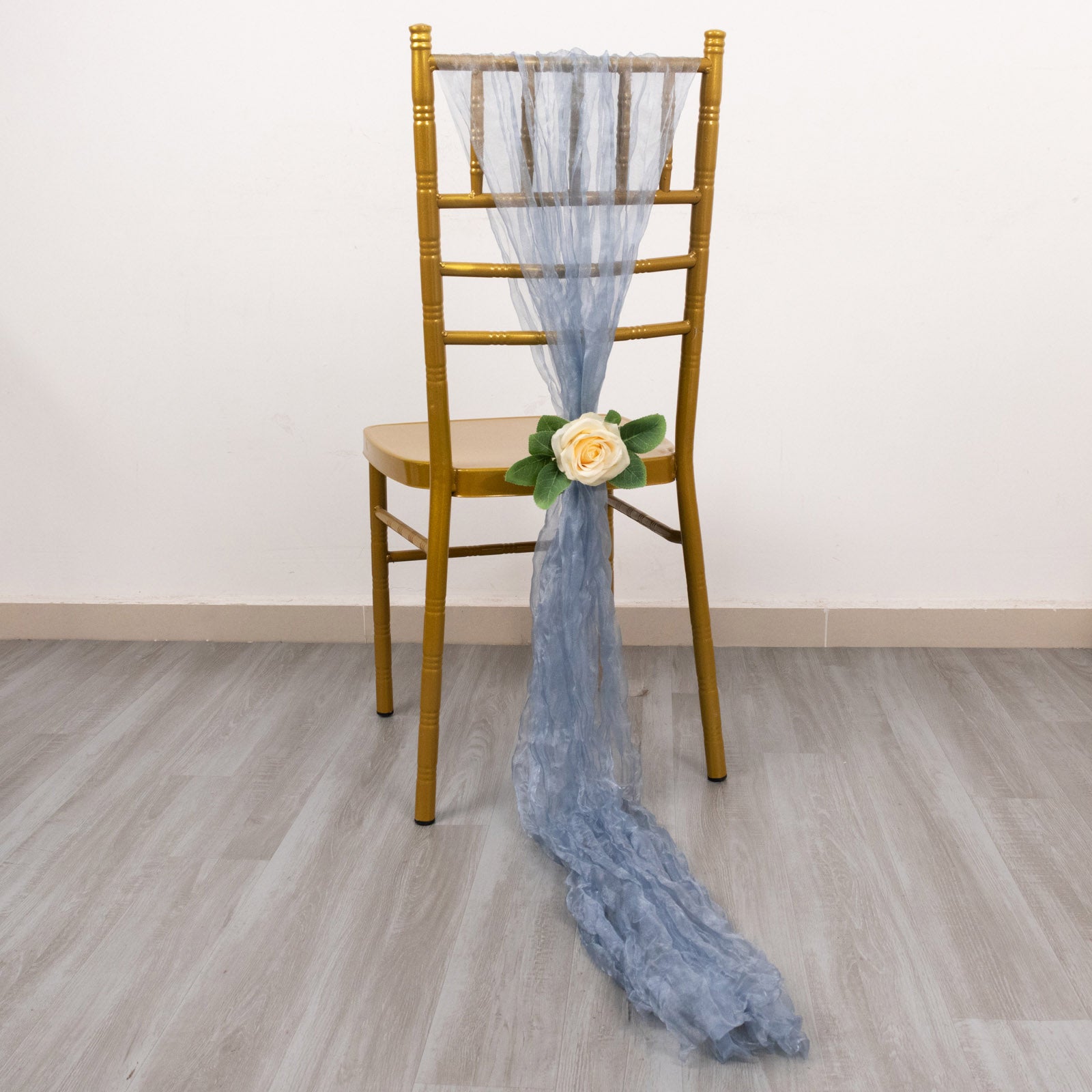 Dusty blue sheer crinkled organza chair sash on a gold chair.