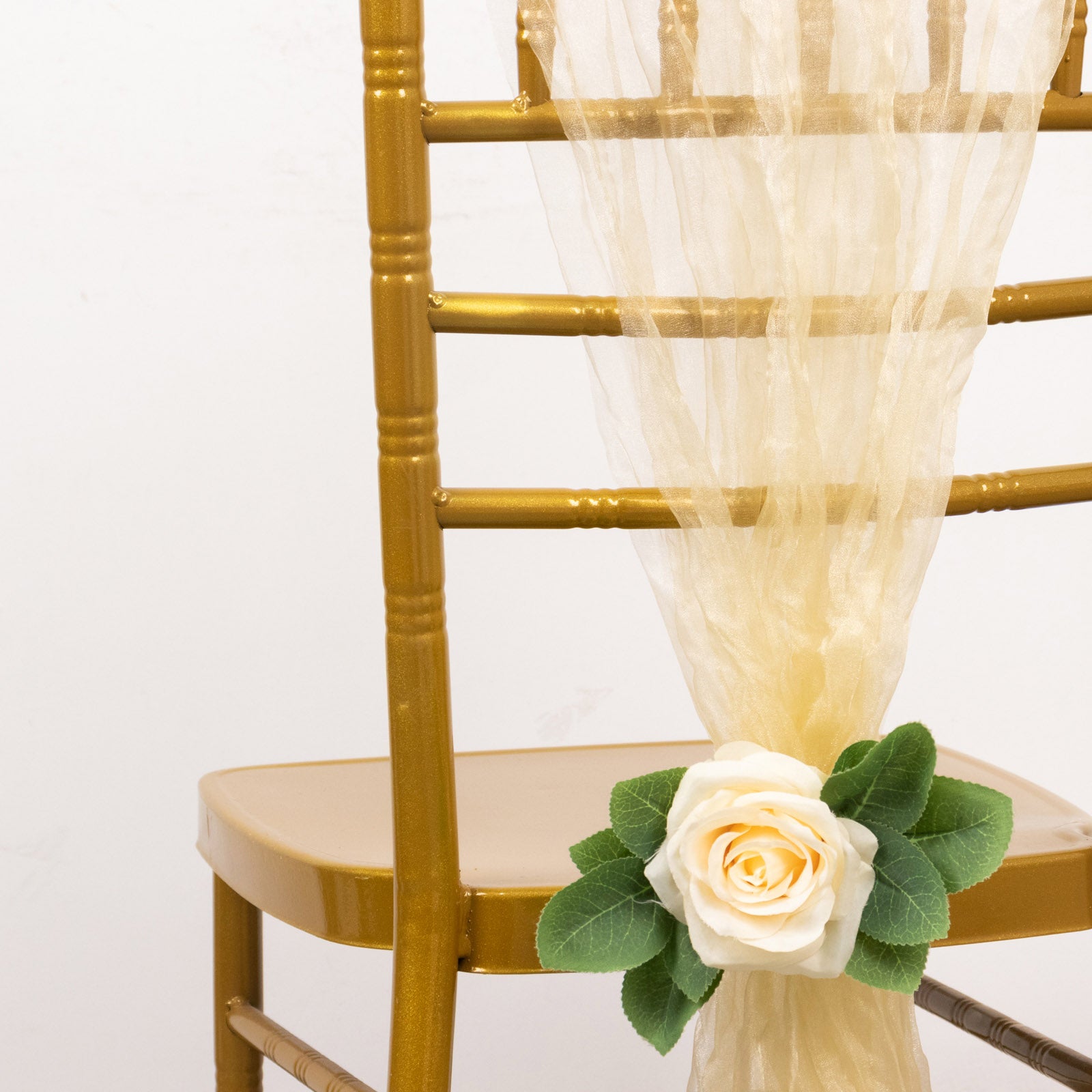 Champagne sheer crinkled organza chair sash on a gold chair.