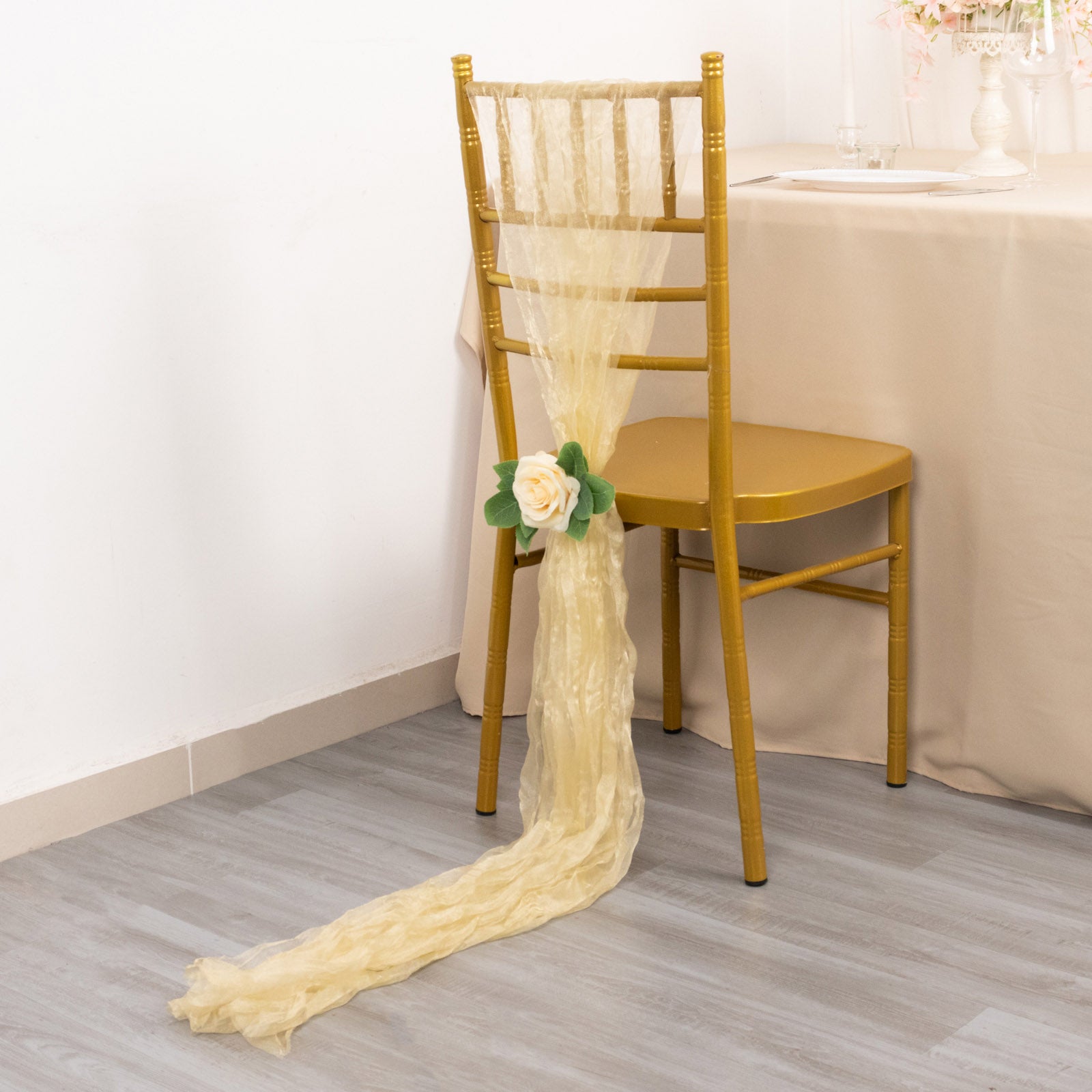 Champagne sheer crinkled organza chair sash draped on a chair.