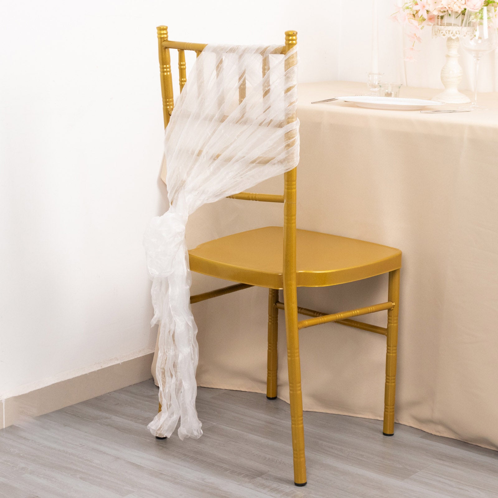 White sheer crinkled organza chair sash on a gold chair.