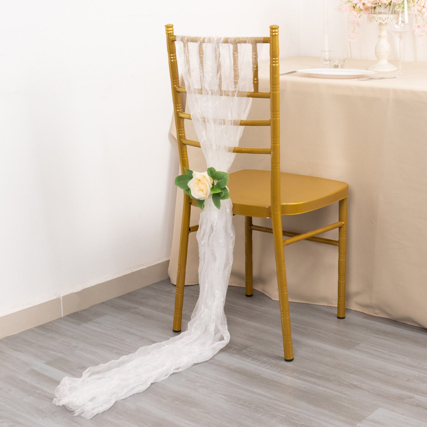 White sheer crinkled organza chair sashes on a gold chair.