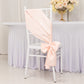 Blush satin chair sash with bow on a white chair at an elegant event.