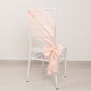 Blush satin chair sash bow on a white chair.