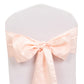 Blush satin chair sash bow on a white chair.