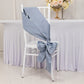 Dusty blue satin chair sash with bow on a white chair.
