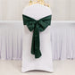 Emerald green satin chair sash bow on a white chair.
