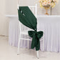 Emerald green satin chair sash tied on a white chair.