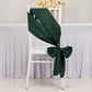Emerald green satin chair sash tied in a bow on a white chair.