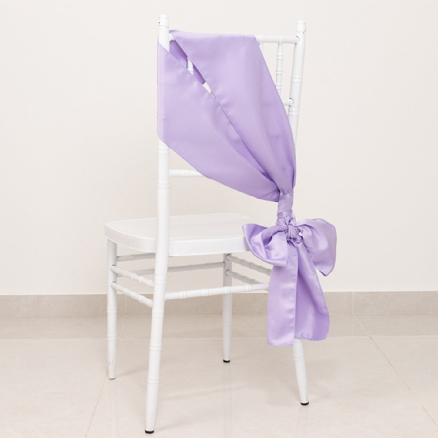 Lavender satin chair sash bow on a white chair.