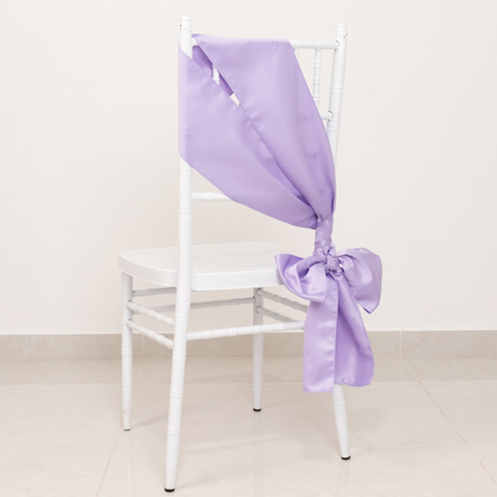 Lavender satin chair sash bow on a white chair.