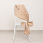 Nude satin chair sash bow elegantly tied on a white chair.