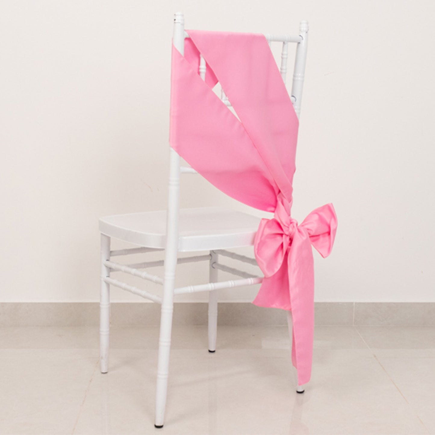 Pink satin chair sash with bow, perfect for elegant events.