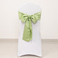 Sage green satin chair sash tied in a bow on a white chair.