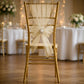 Champagne organza chair sash tied in a bow on a gold chair.