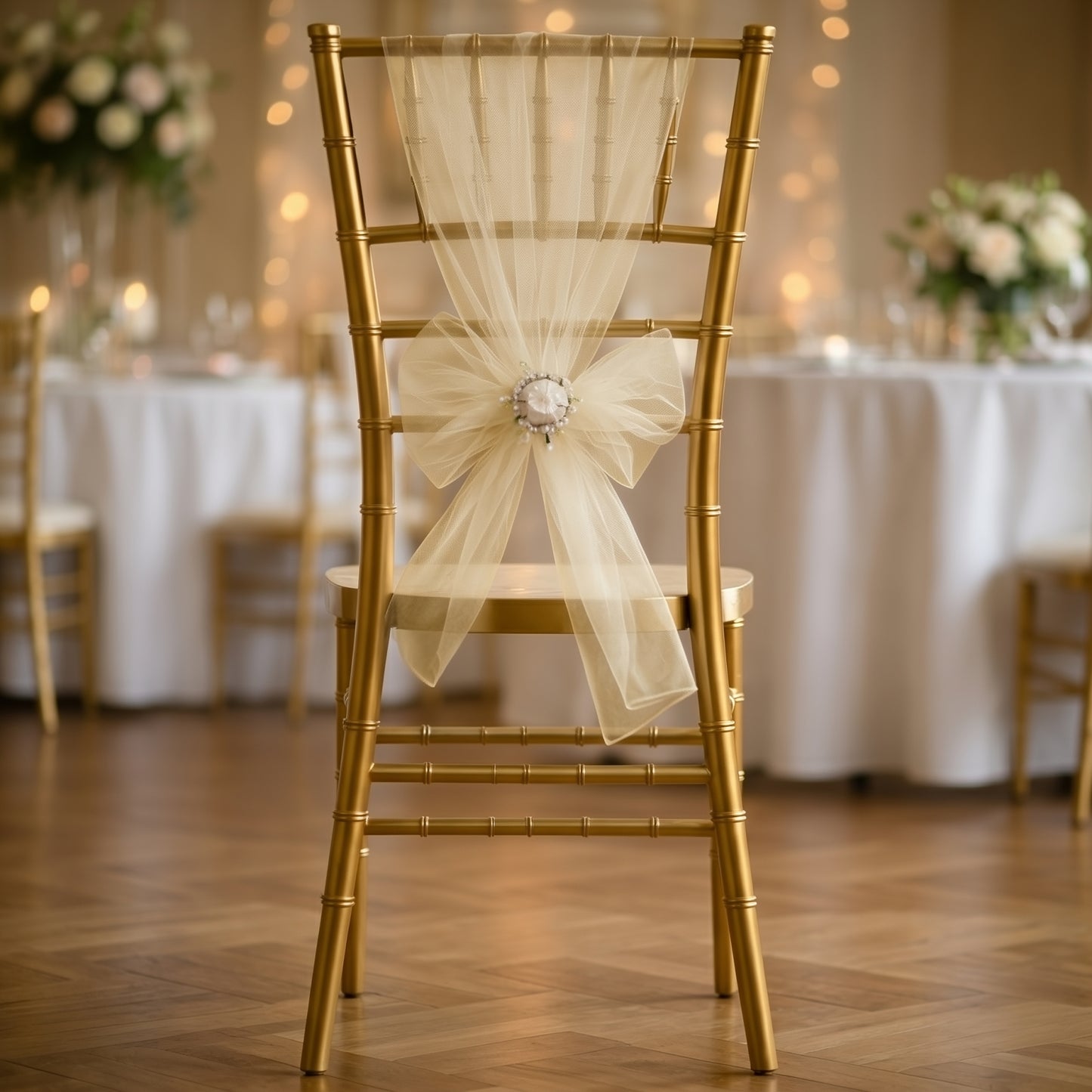 Champagne organza chair sash tied in a bow on a gold chair.