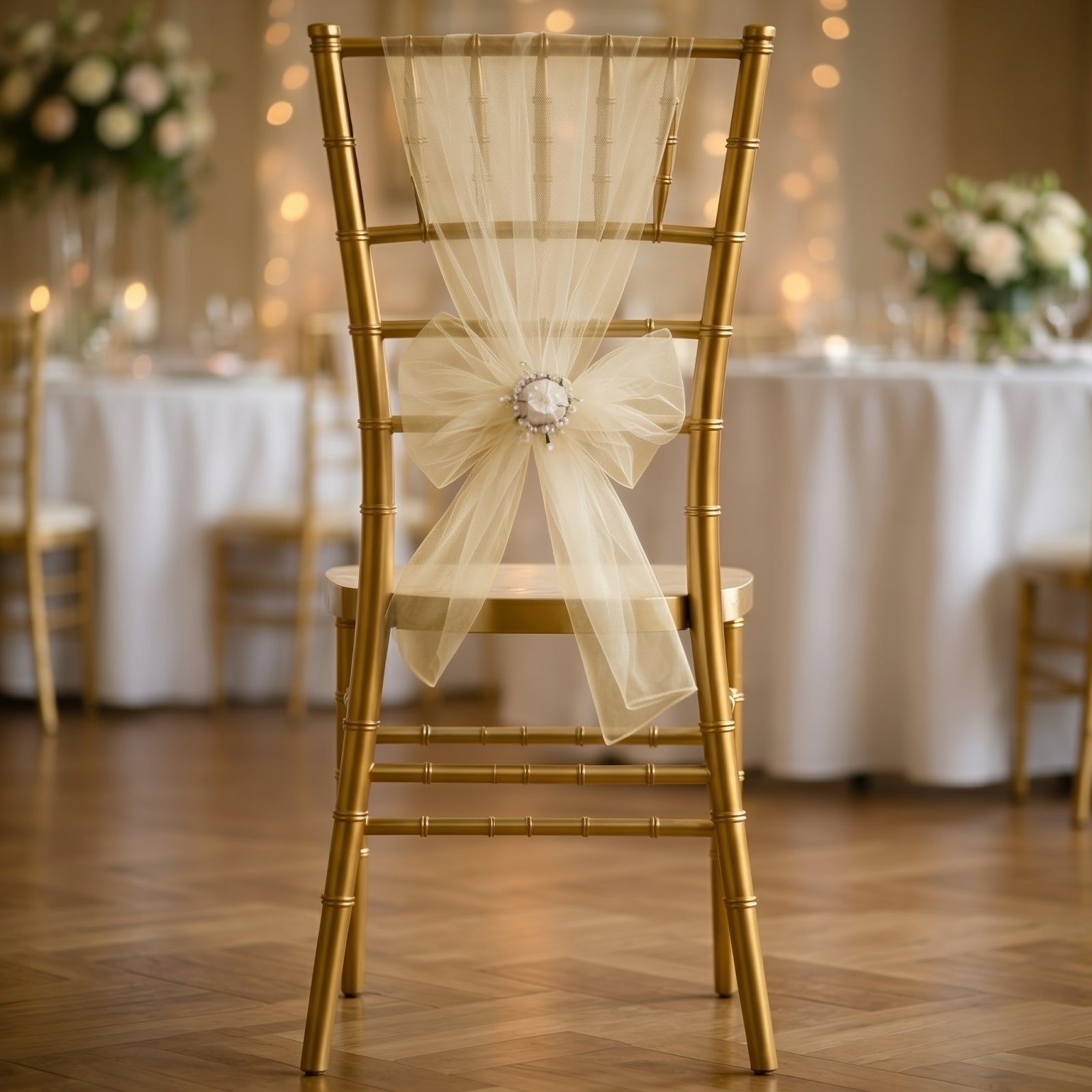 Champagne organza chair sash tied in a bow on a gold chair.