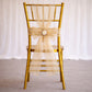 Champagne organza chair sash tied in a bow on a gold chair.