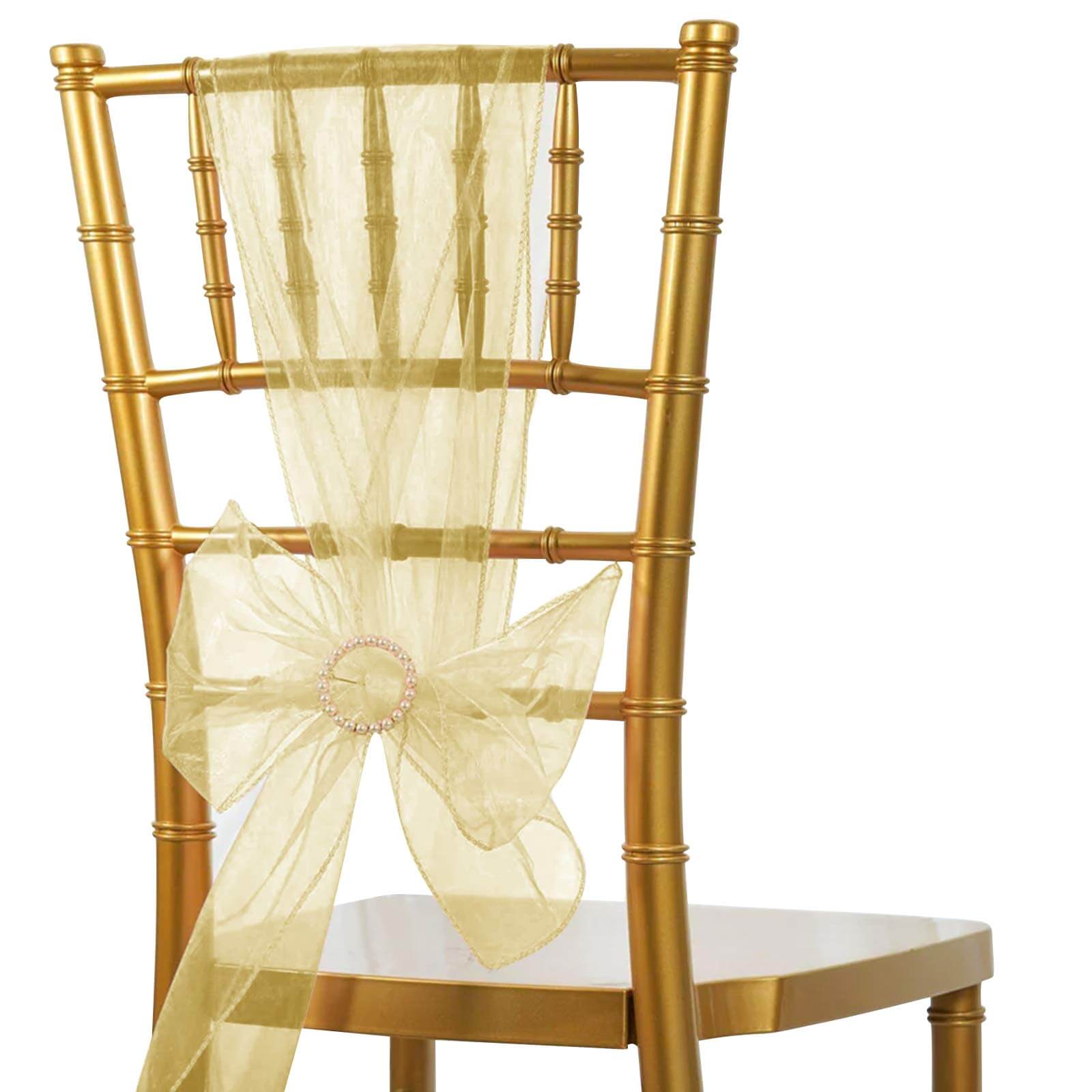 Champagne organza chair sash bow tied on a gold chiavari chair.