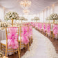 Fuchsia organza chair sashes adorning elegant wedding reception chairs.