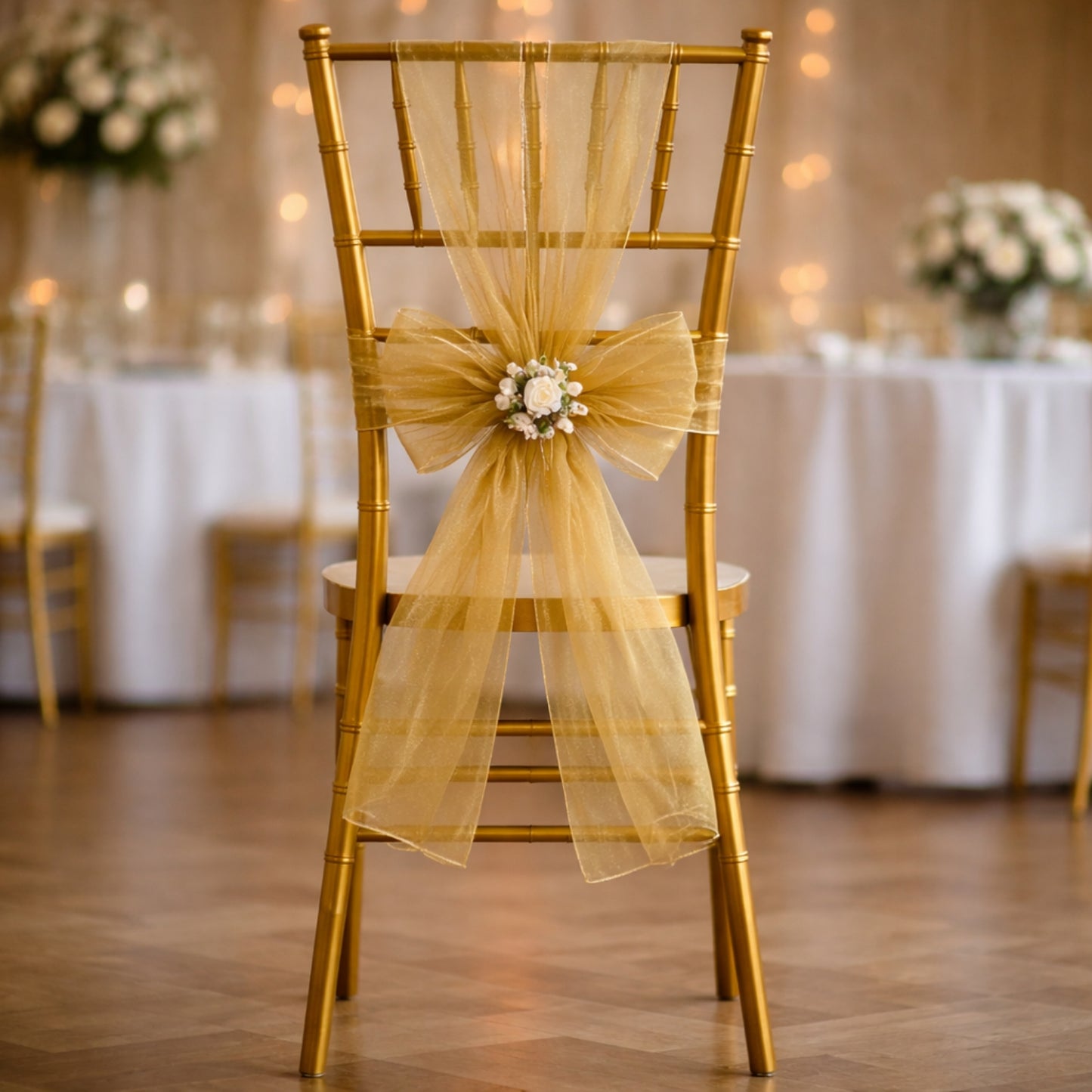 Gold organza chair sash with bow on a wedding chair.