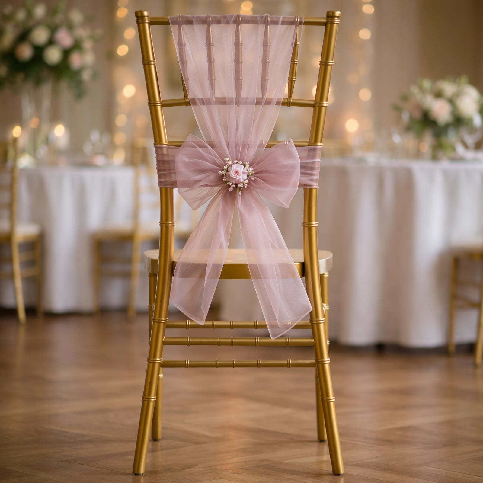 Dusty rose organza chair sash tied on a gold chiavari chair.