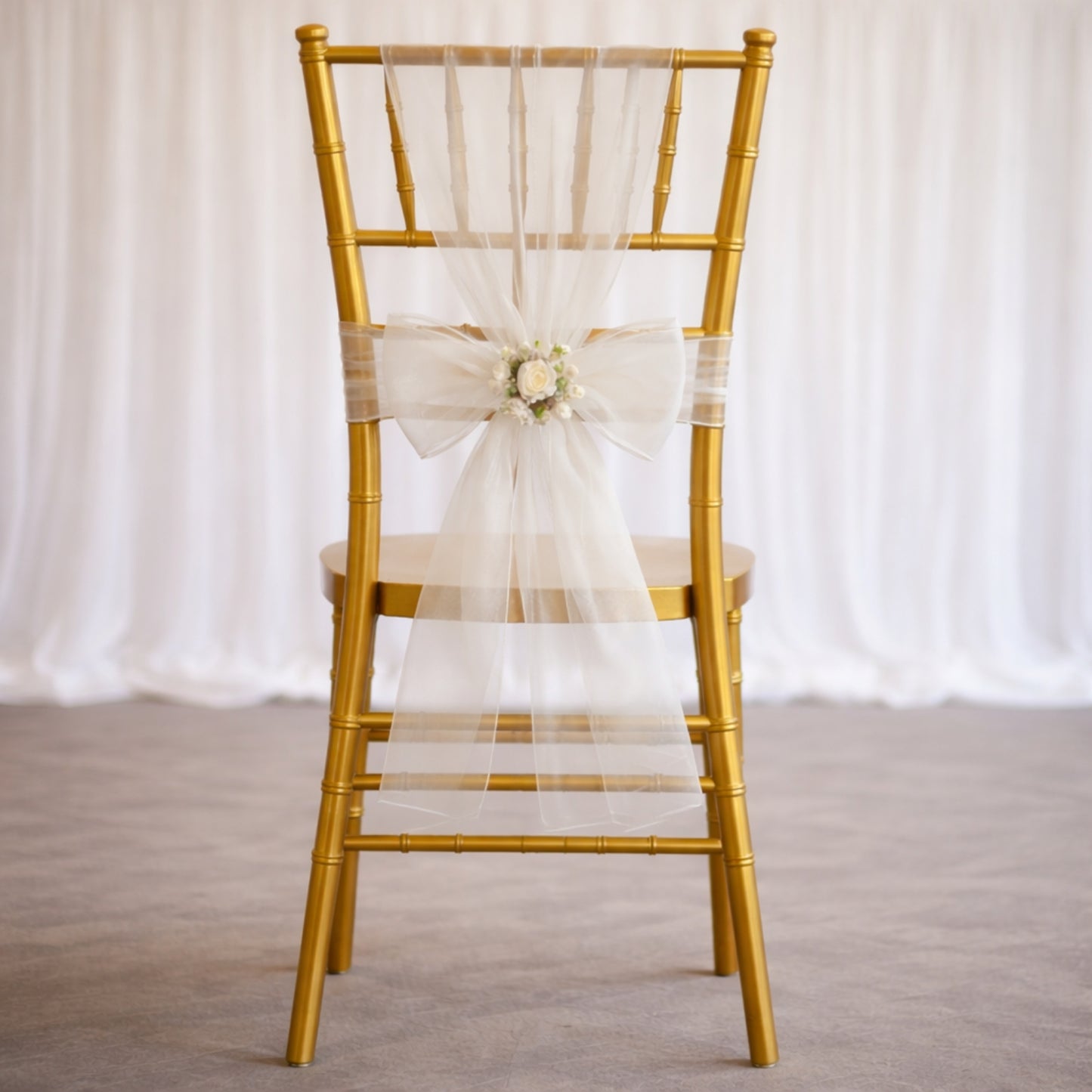 White organza chair sash bow on a gold chair, perfect for weddings.
