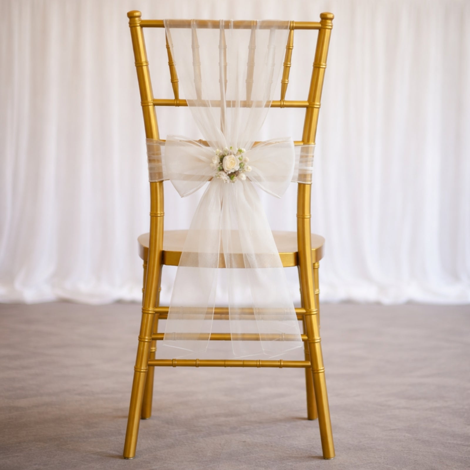White organza chair sash bow on a gold chair, perfect for weddings.