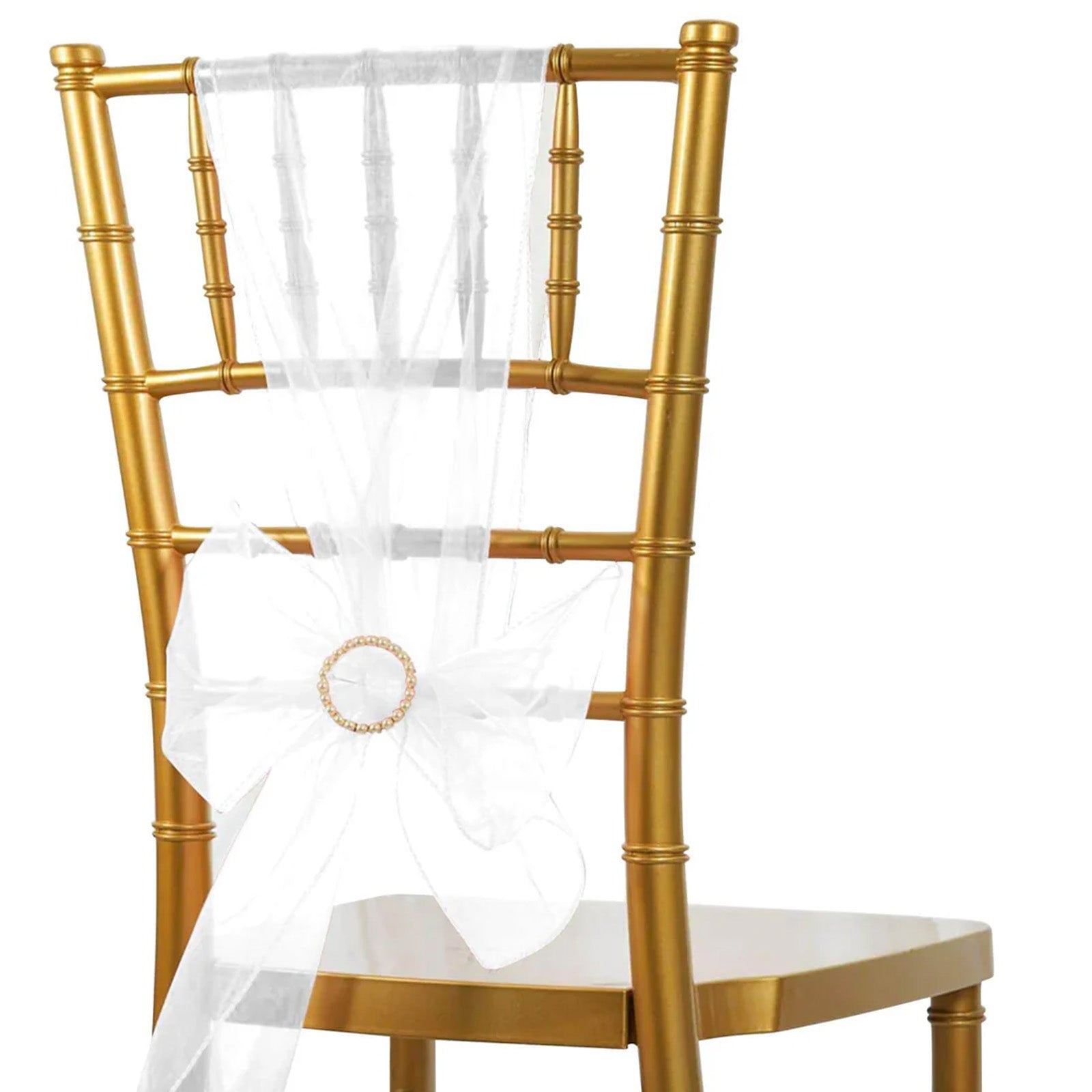 White organza chair sash tied in a bow on a gold chair.