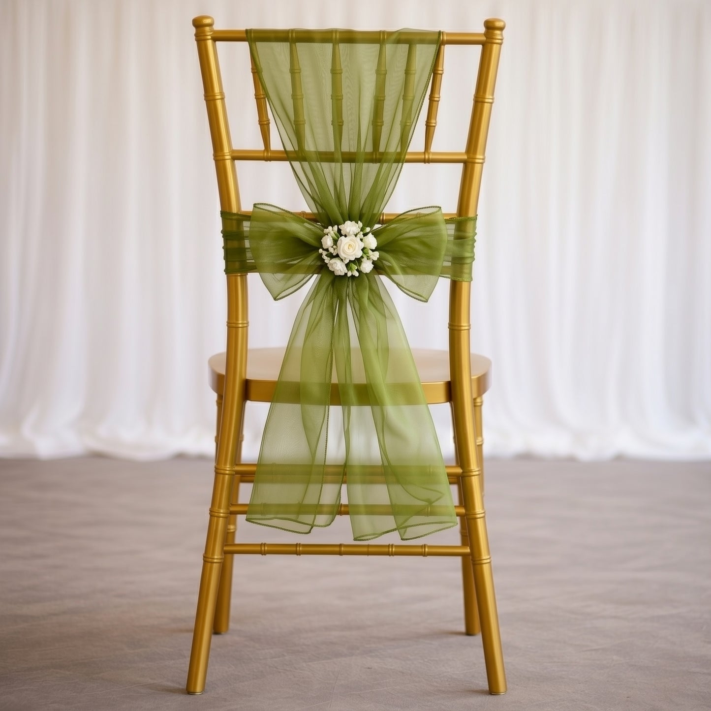 Olive green organza chair sash tied on a gold chiavari chair.