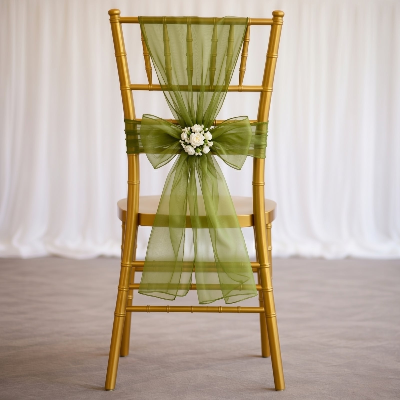 Olive green organza chair sash tied on a gold chiavari chair.
