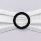 Black diamond circle napkin ring pin brooch on white fabric.