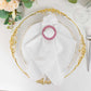 Pink diamond circle napkin ring brooch on a white napkin.