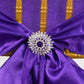 Silver metal snowflake chair sash band buckle with diamonds on purple fabric.