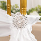 Silver snowflake chair sash band buckle with rhinestones on a white chair cover.