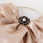 Black pearl floral metal chair sash bow pin with gold rim.