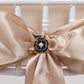 Black pearl floral chair sash bow pin with gold rim.