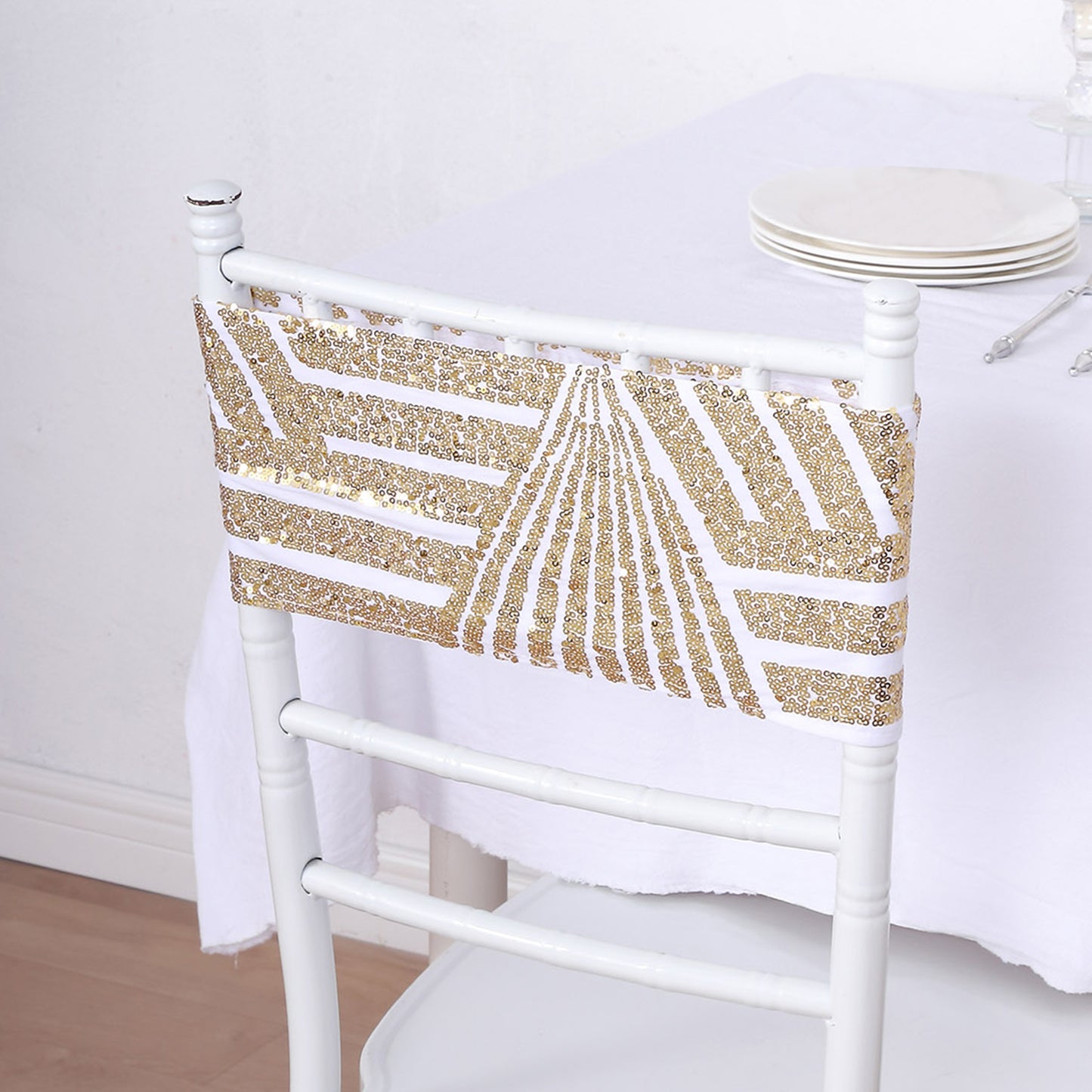 Gold sequin chair sash band on white chair, perfect for elegant events.