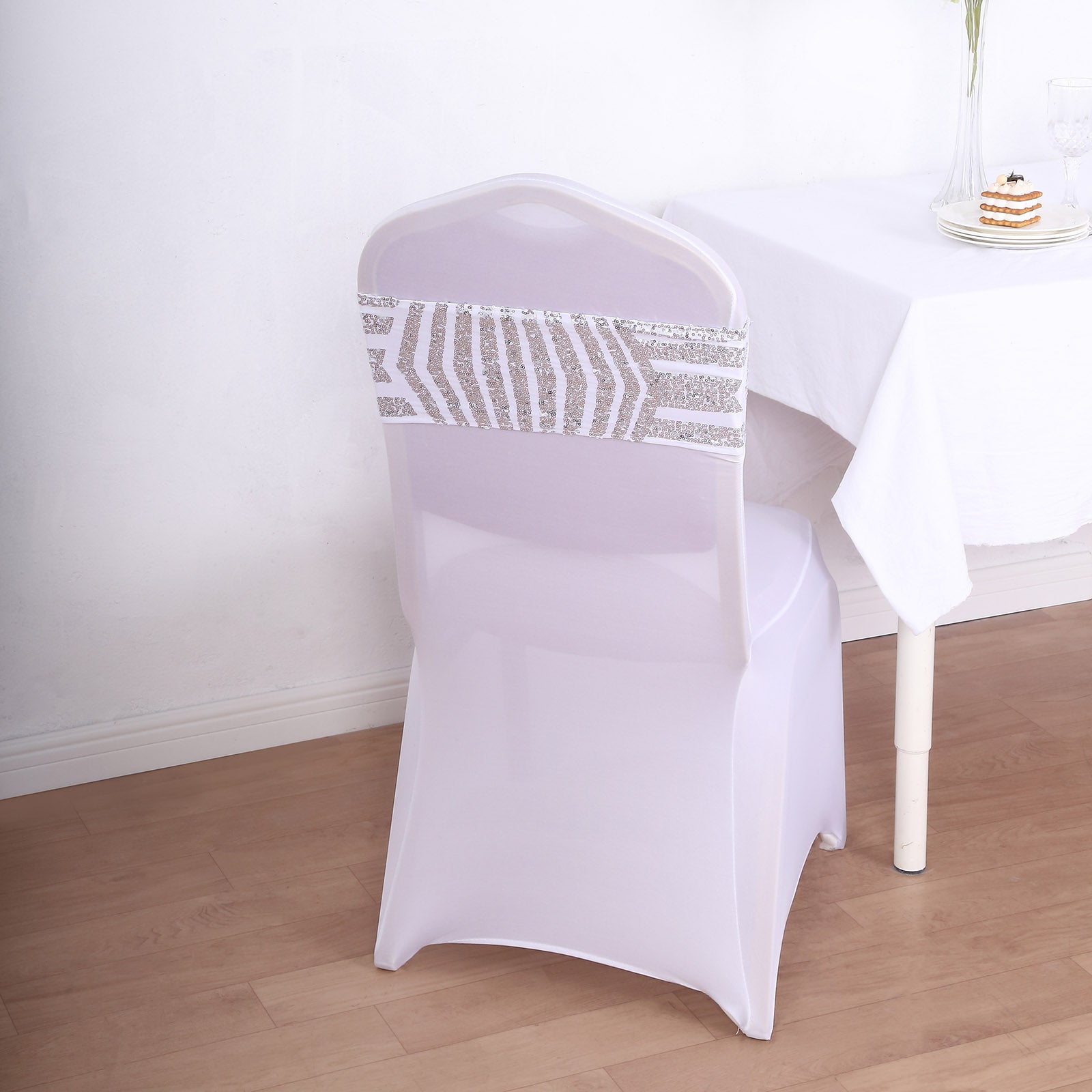 Silver sequin chair sash band on a white spandex chair.