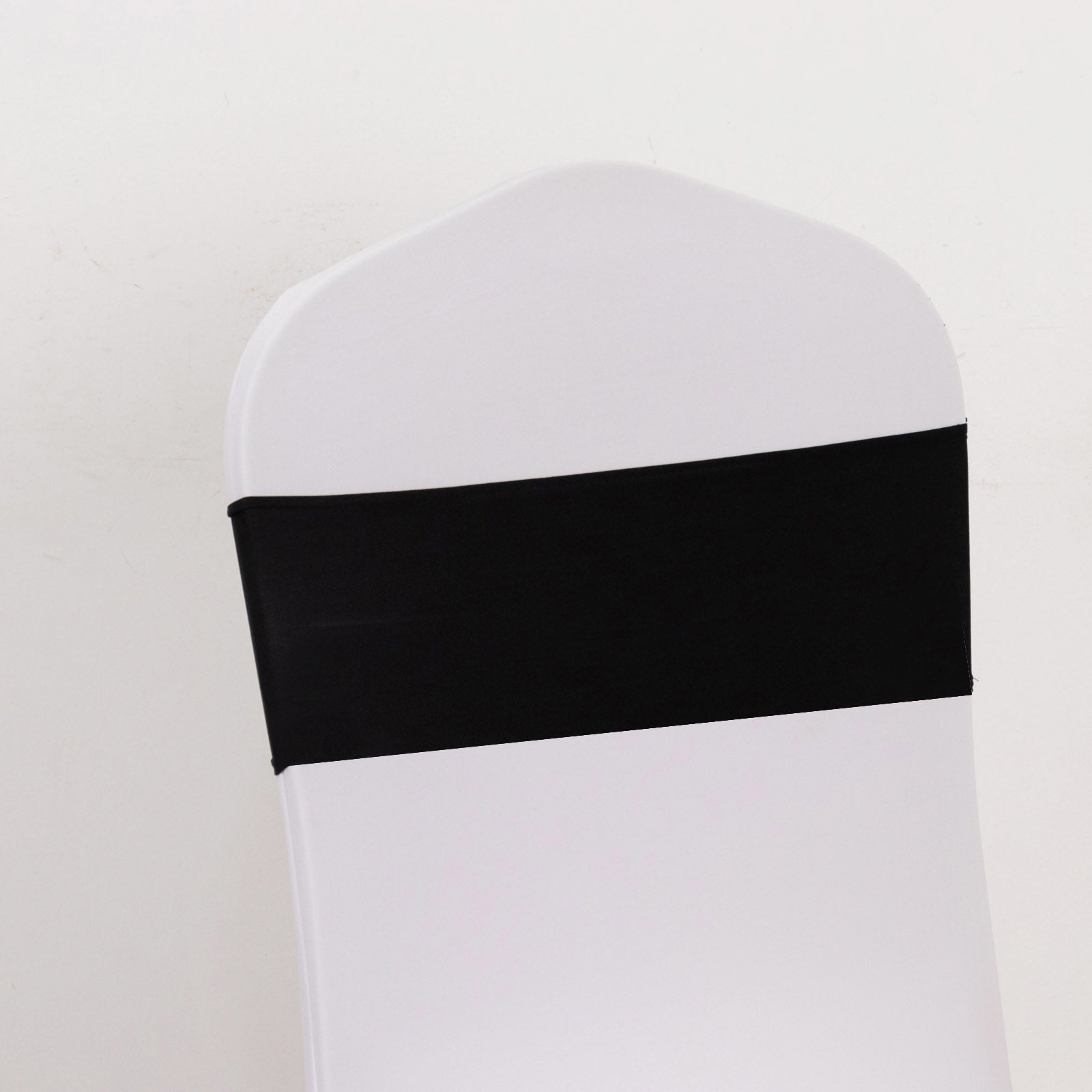 Black spandex chair sash with gold diamond buckle on white chair.