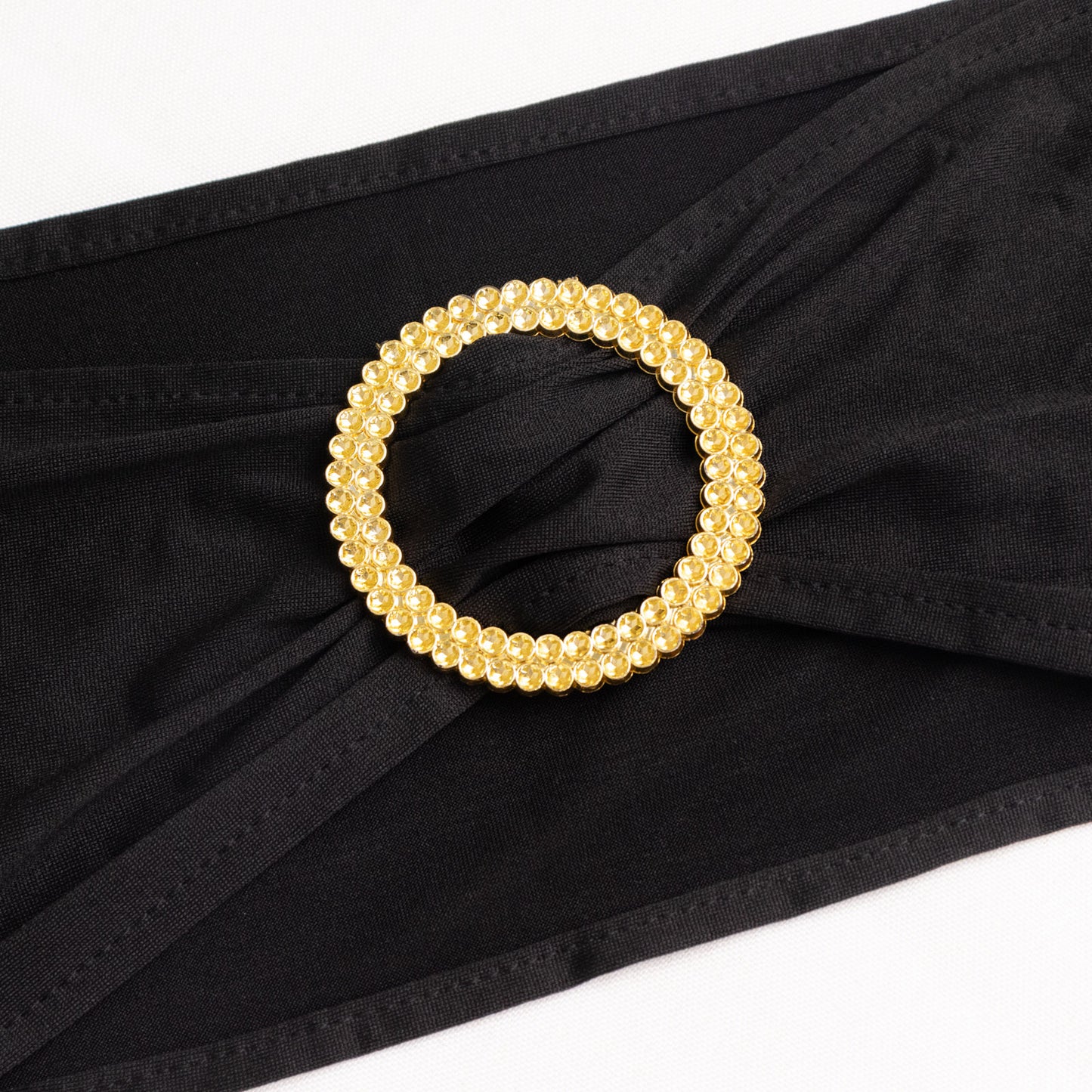 Black spandex chair sash with gold diamond buckle. Elegant and stretchy design.