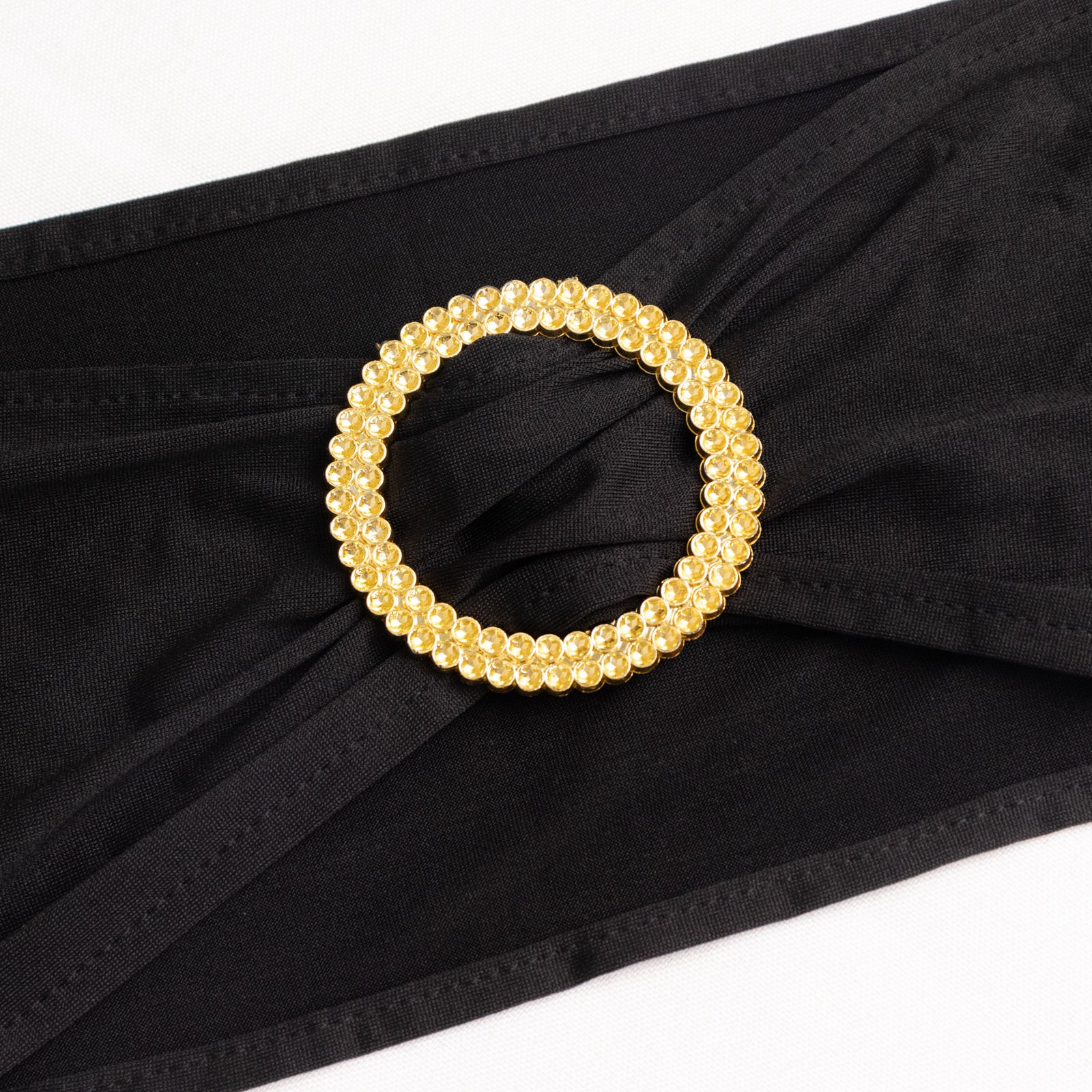 Black spandex chair sash with gold diamond buckle. Elegant and stretchy design.