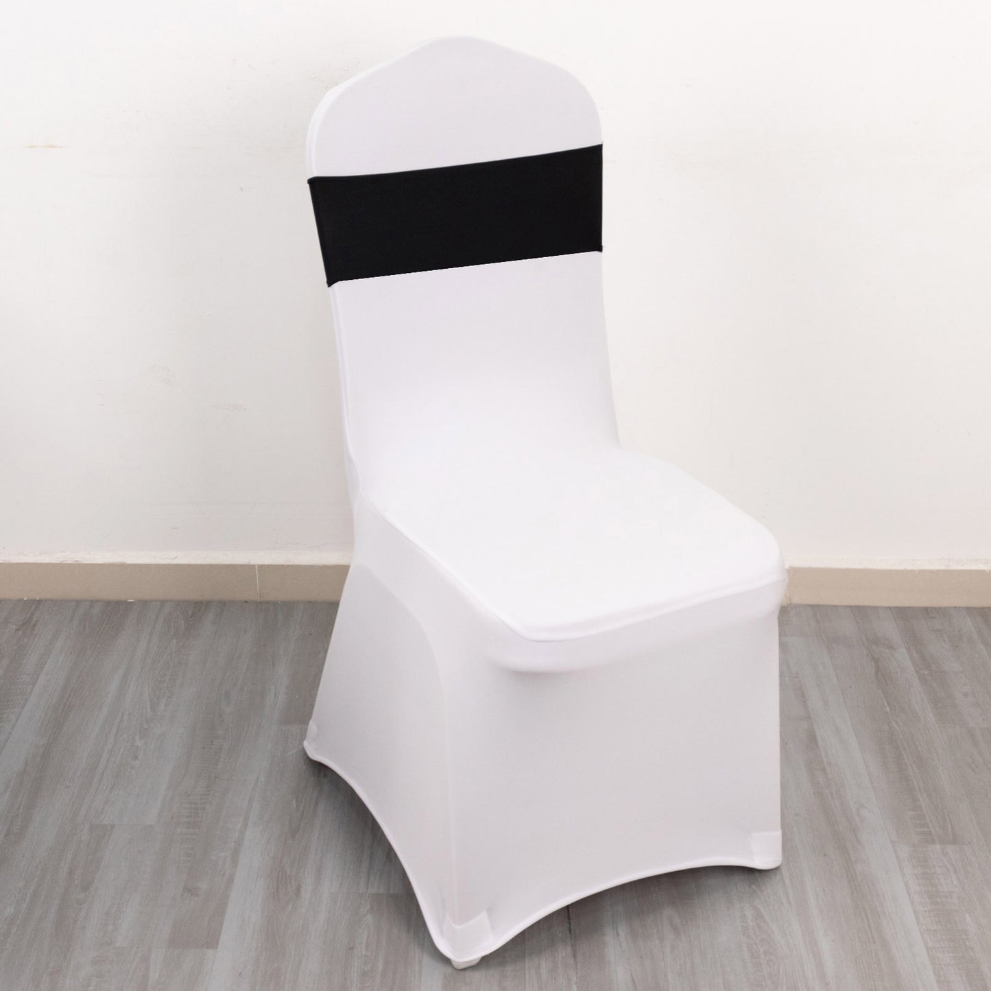 Black spandex chair sash with gold diamond buckle on a white chair.