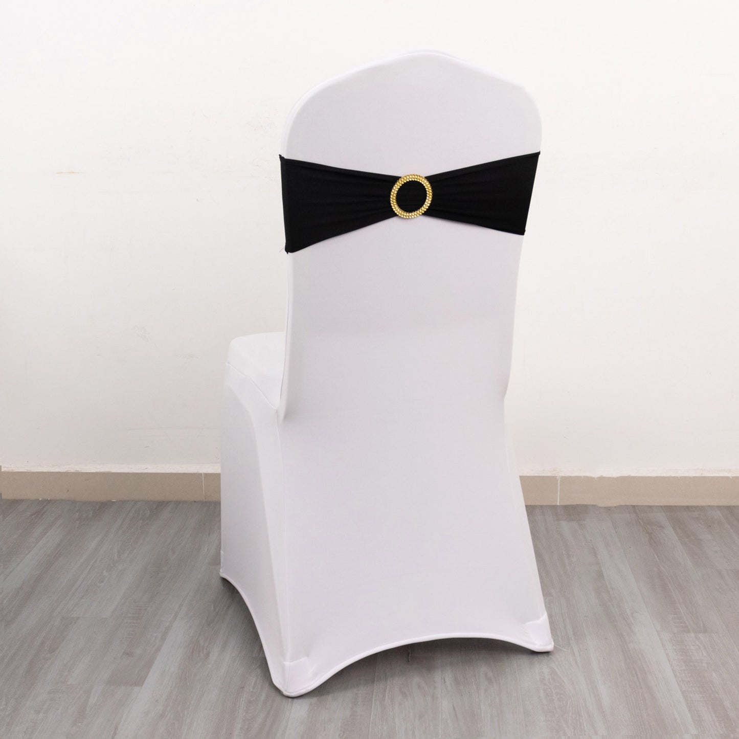 Black spandex chair sash with gold diamond buckle on a white chair.