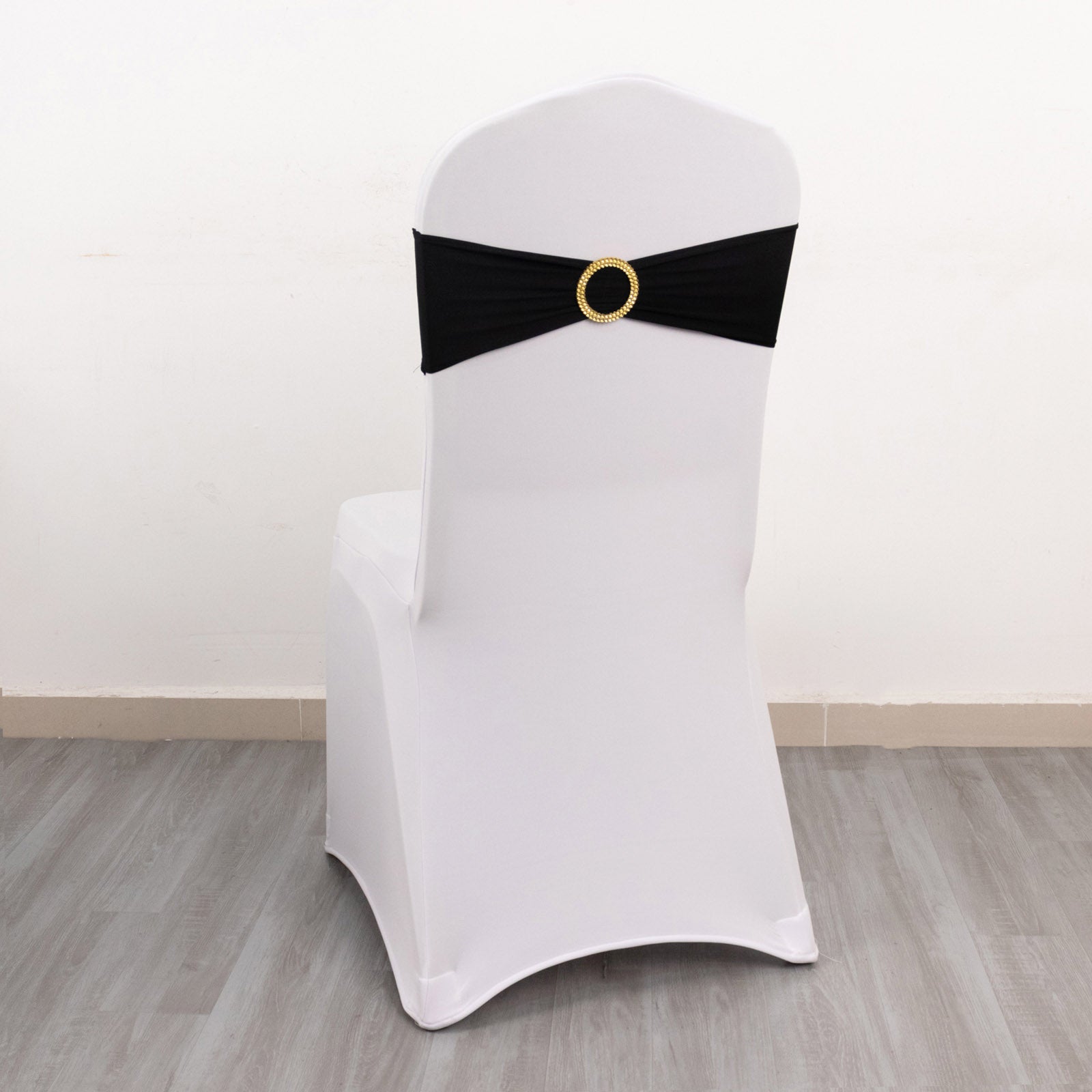 Black spandex chair sash with gold diamond buckle on a white chair.
