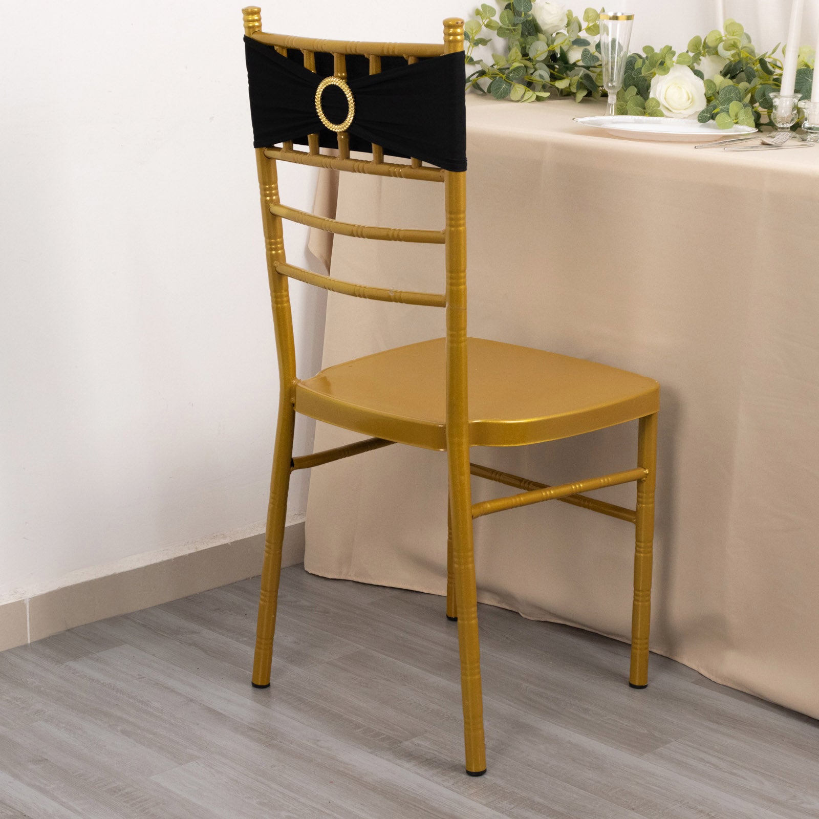 Black spandex chair sash with gold diamond buckle on a gold chair.