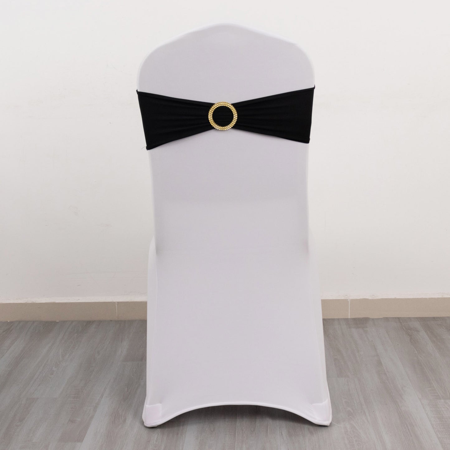Black spandex chair sash with gold diamond buckle on a white chair.