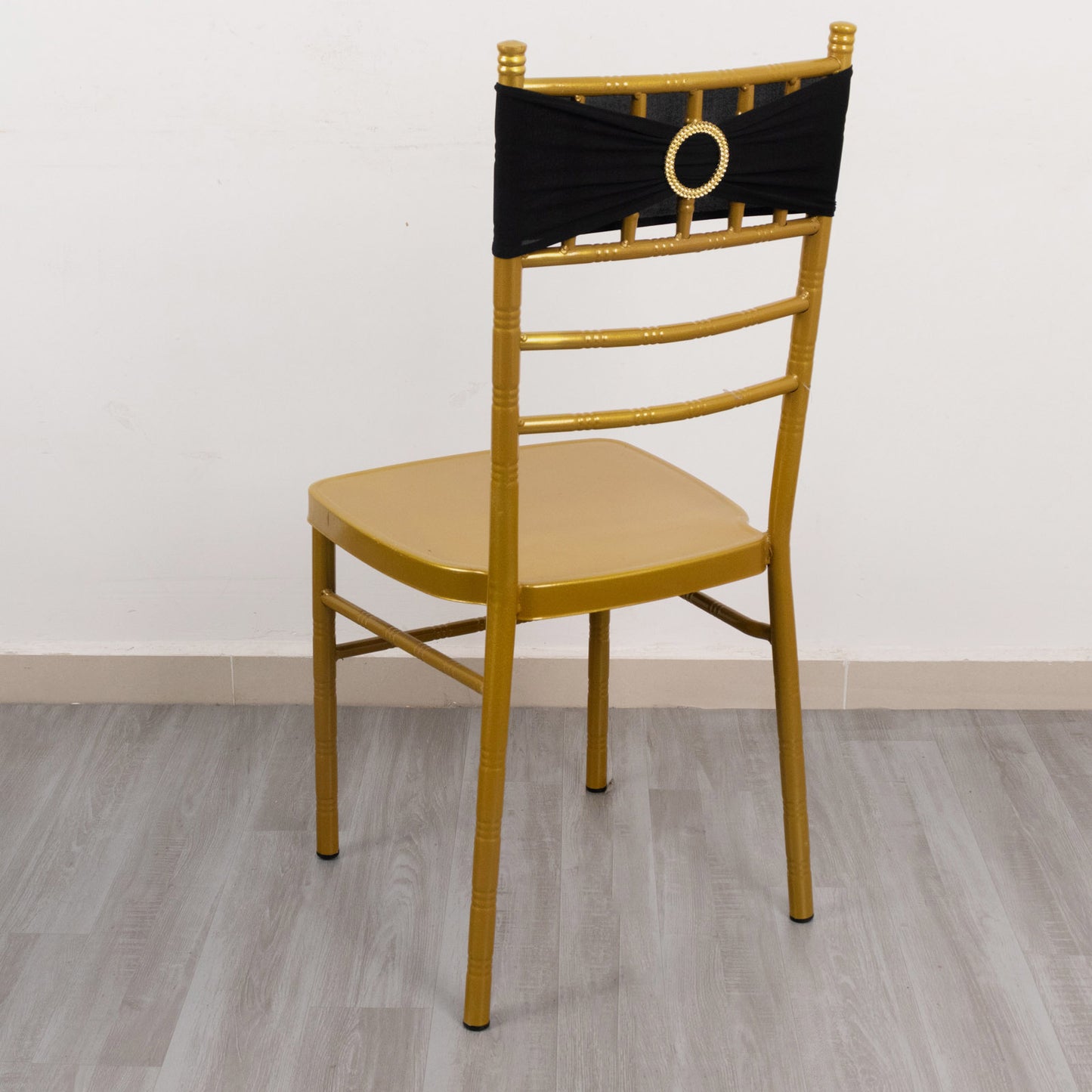 Black spandex chair sash with gold diamond buckle on a gold chair.