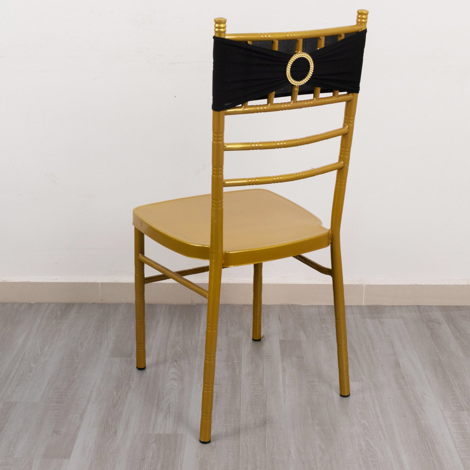 Black spandex chair sash with gold diamond buckle on a gold chair.