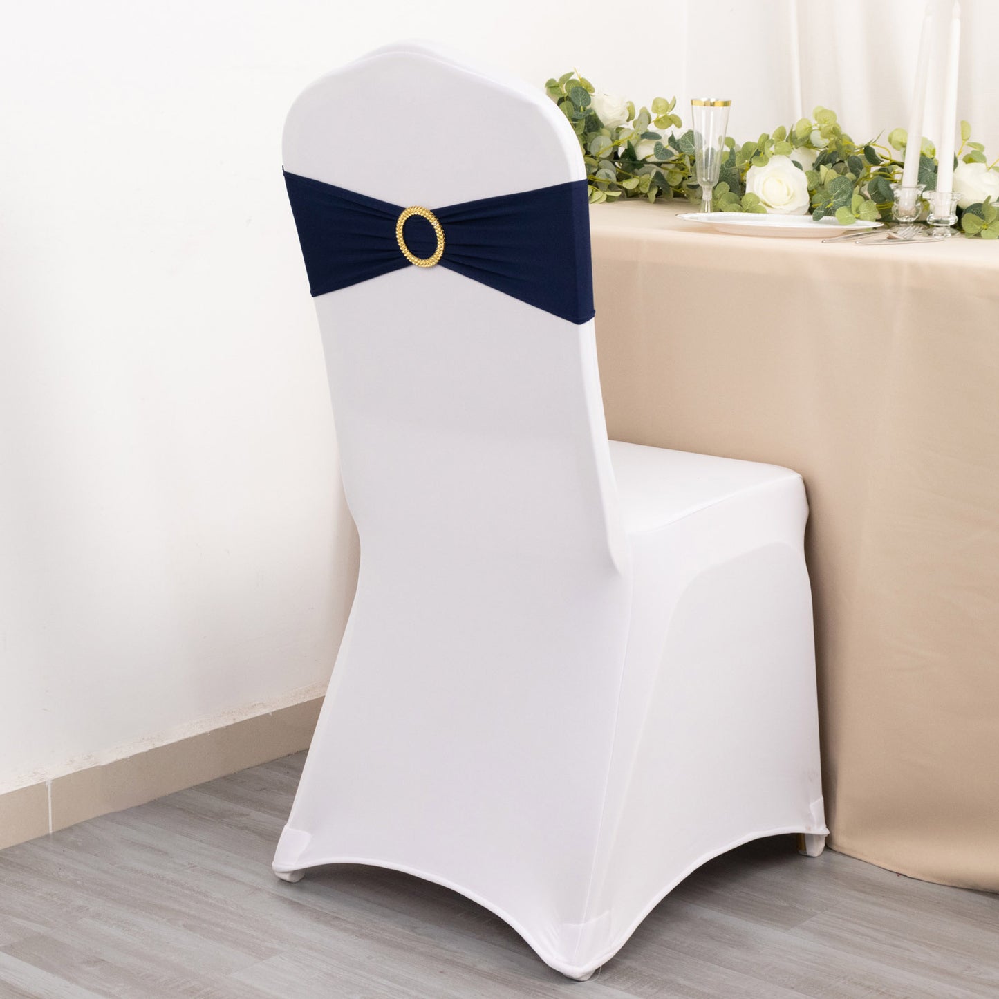 Navy blue spandex chair sash with gold diamond buckle on a white chair.