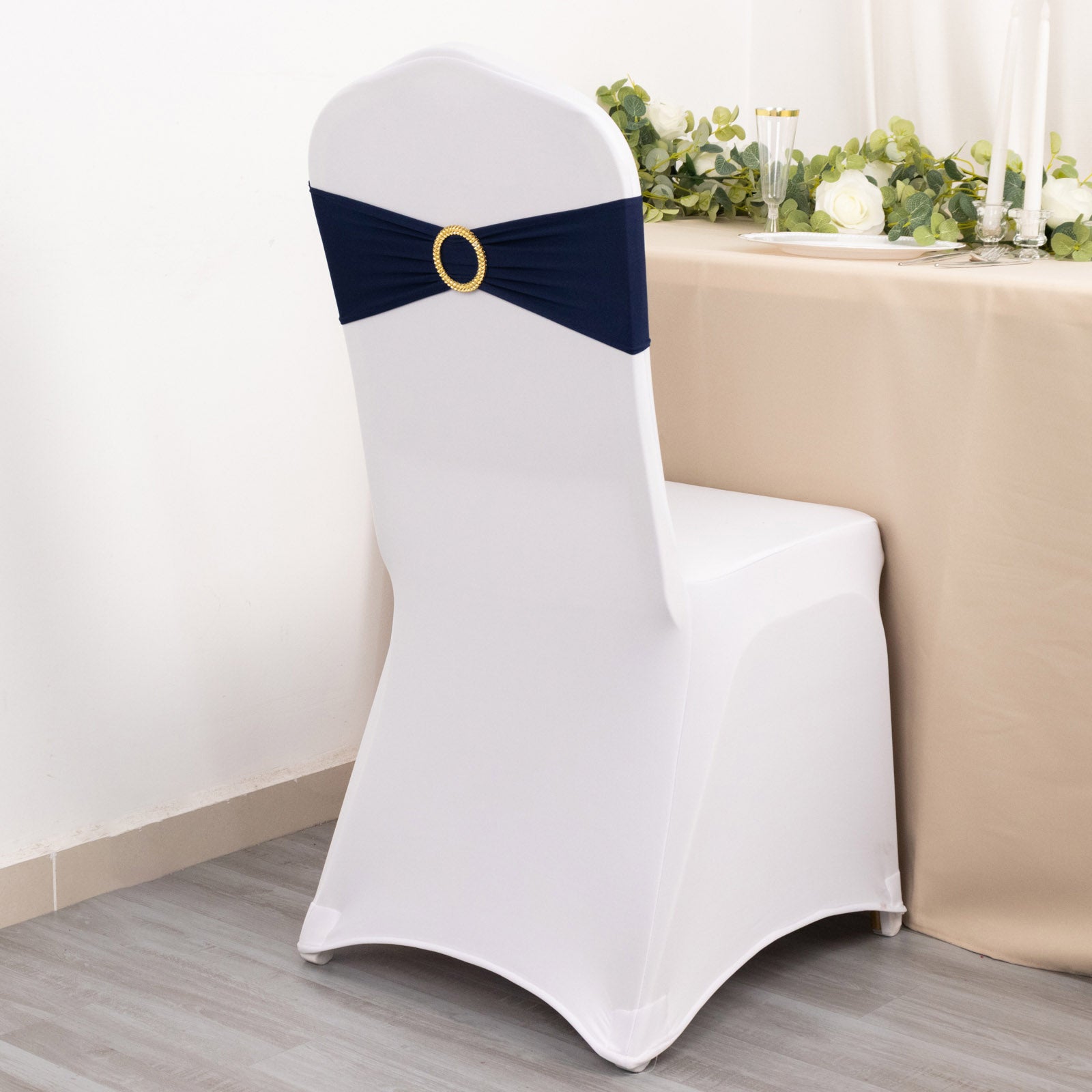 Navy blue spandex chair sash with gold diamond buckle on a white chair.
